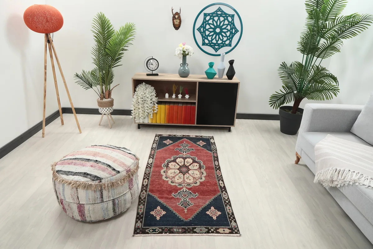 Area rug placed in a modern living room setting, showing its scale next to a sofa and pouf.