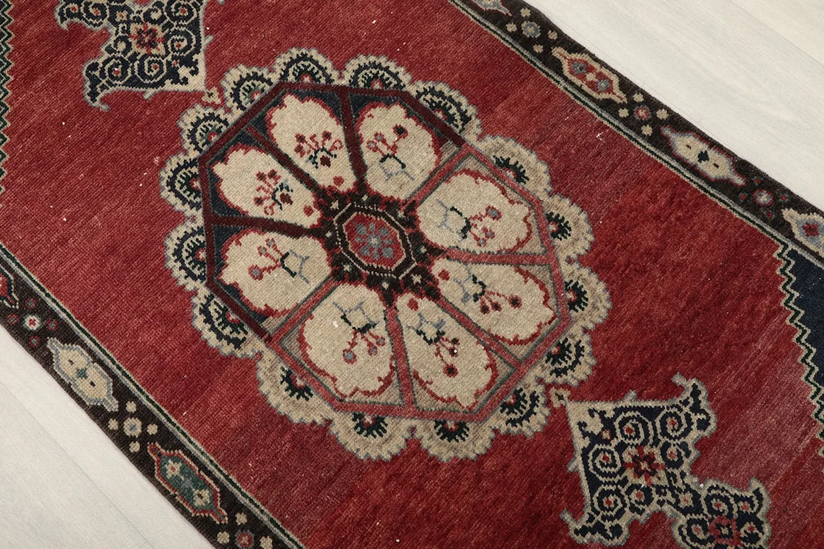 Detail shot of the central beige medallion and surrounding red field, showing the intricate motifs.
