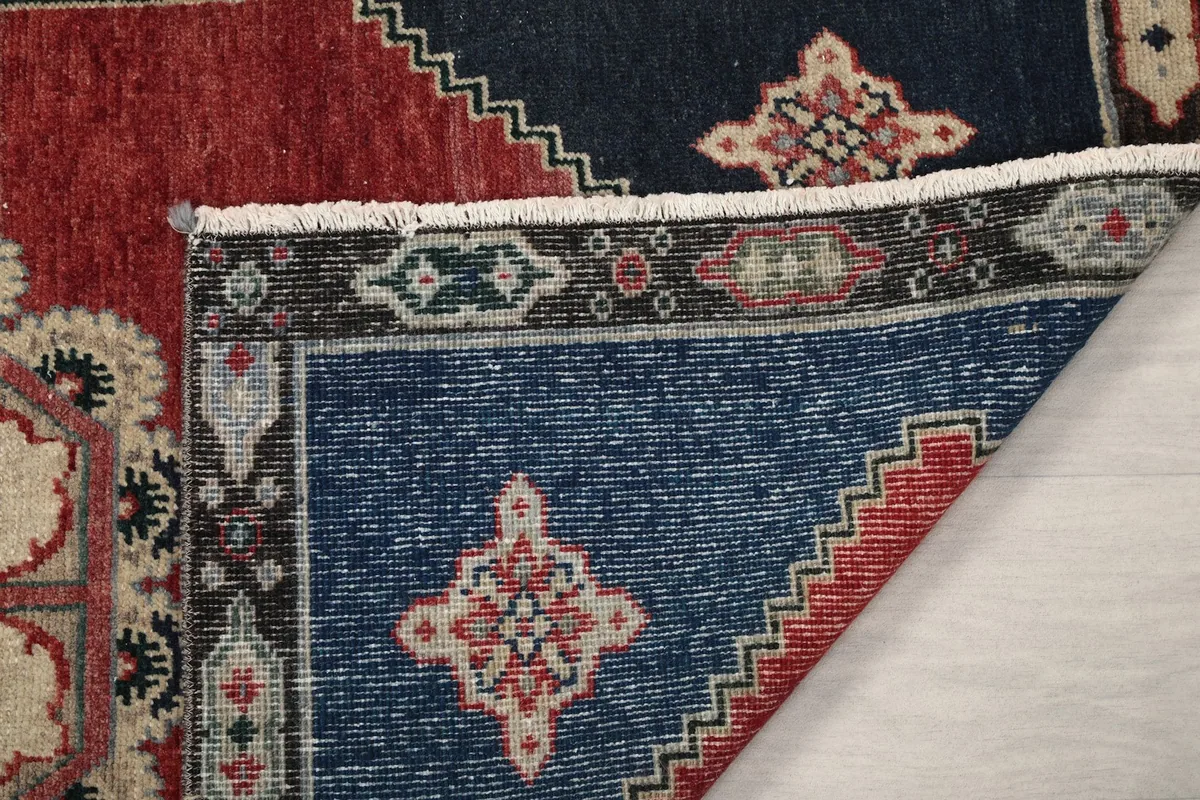 Close-up of the rug's pile and foundation, revealing the wool texture and hand-knotted quality.