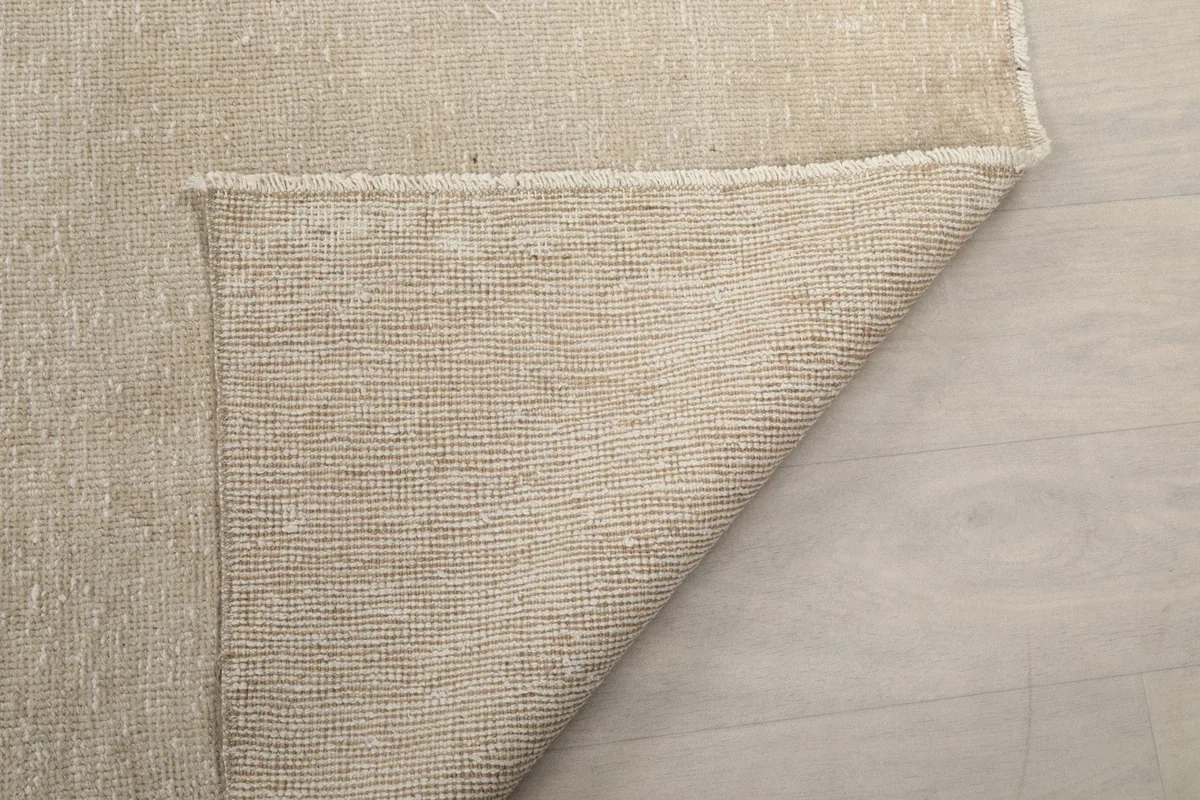 Another view of the rug's back, showing the consistent knotting on the cotton foundation.