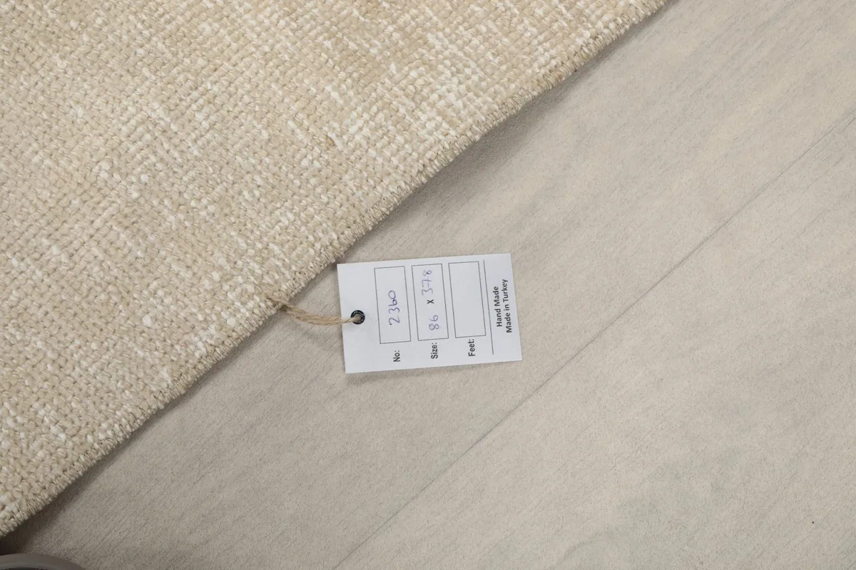 Rug tag displaying the dimensions 2'10" x 12'5" (86 x 378 cm) and origin information.