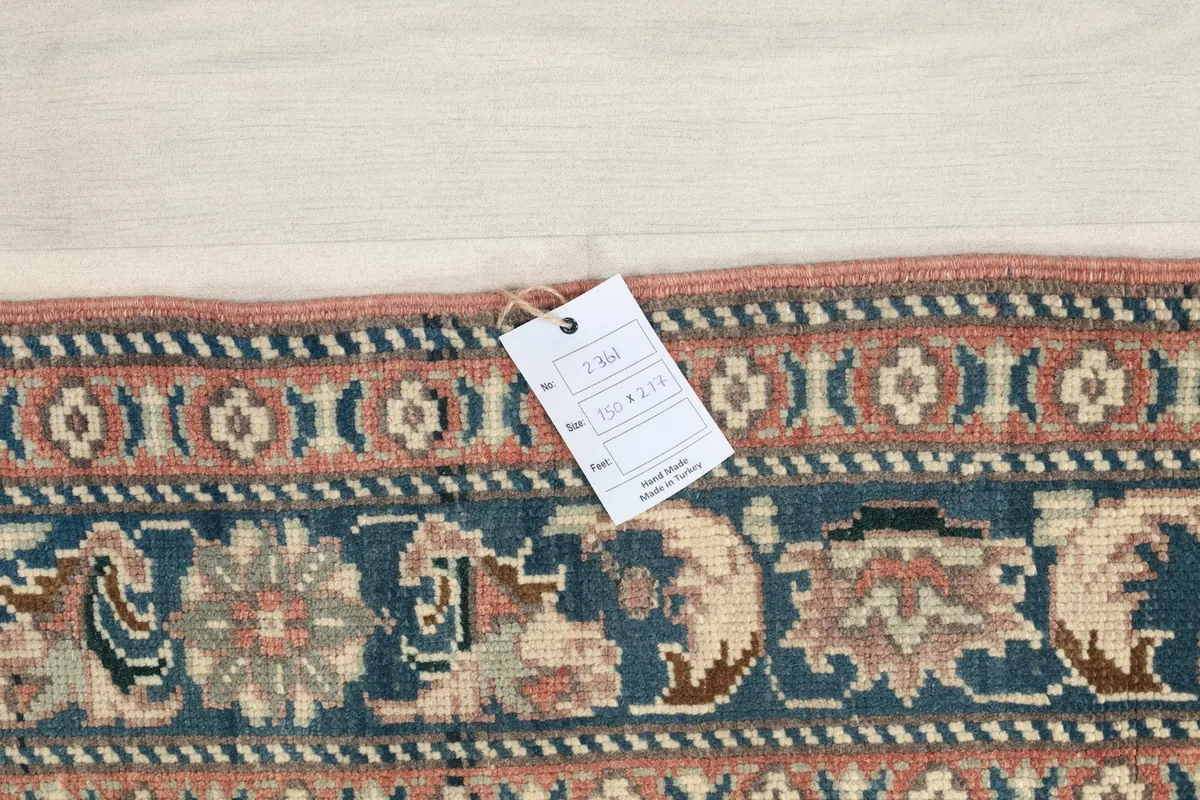 Close-up of the rug's border with a product tag, showing the hand-knotted detail