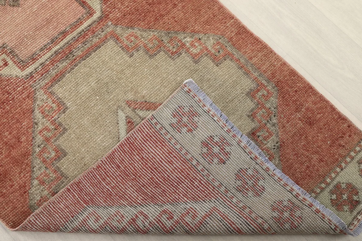 Folded corner of the rug revealing the hand-knotted cotton foundation and wool pile