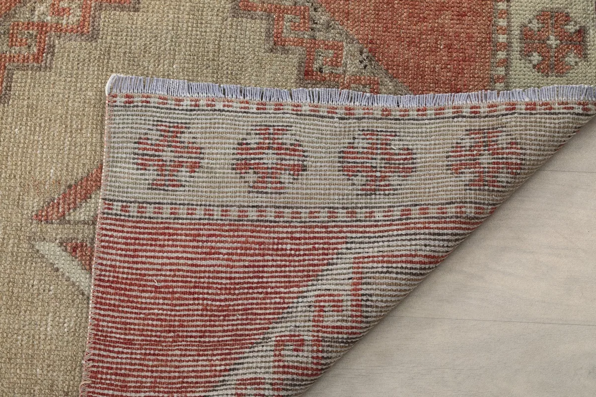 Underside of the rug showing the tight hand-knotted construction and fringe