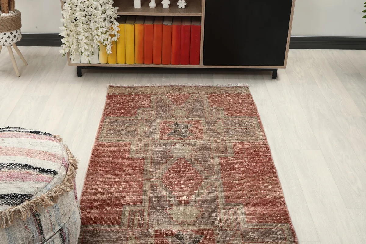 Overhead view of a section of the runner rug in a room, next to a decorative pouf