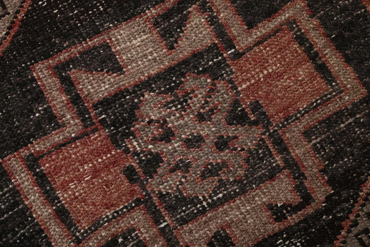 Macro detail of the hand-knotted wool pile and intricate tribal patterns
