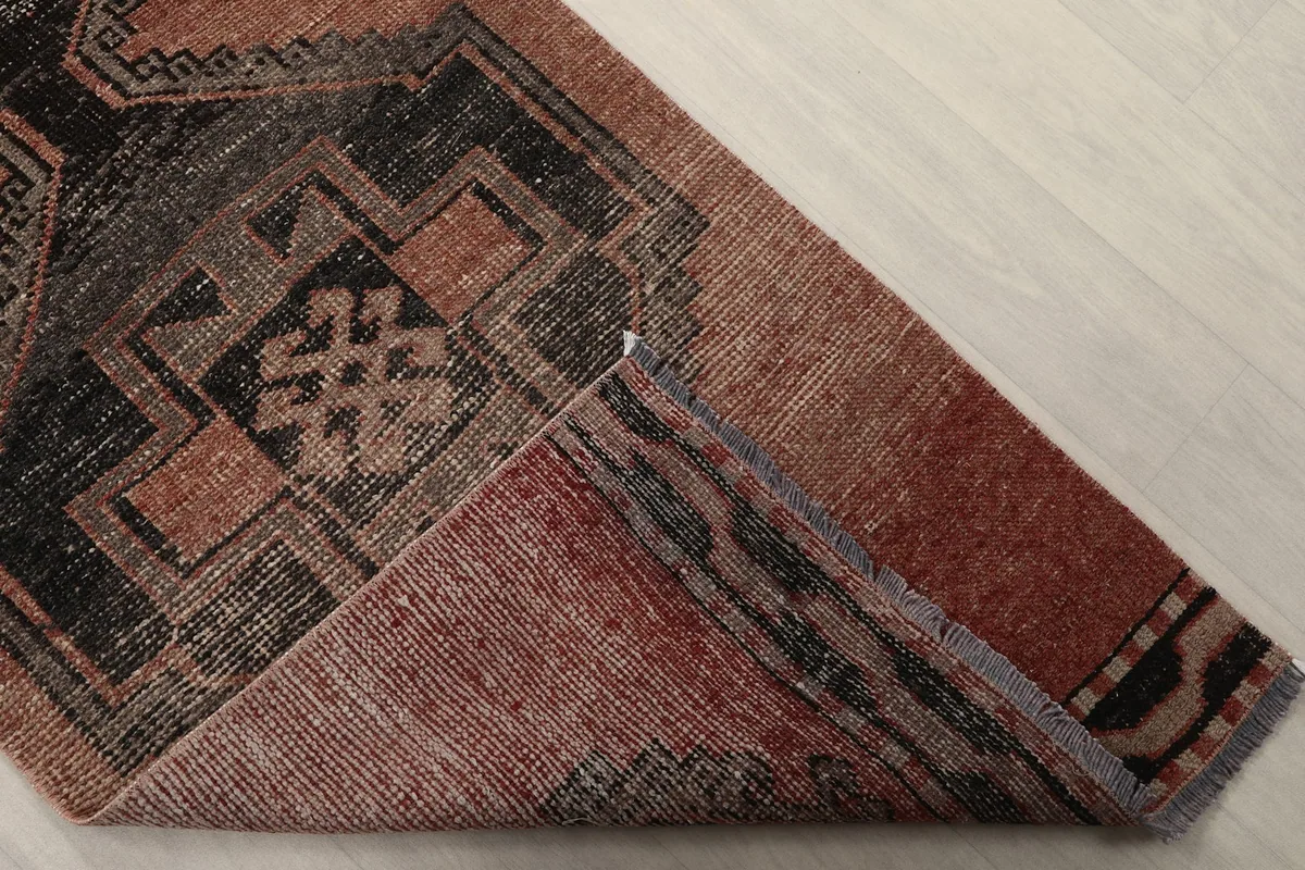 View of the back of the rug, folded to show the cotton foundation and knotting