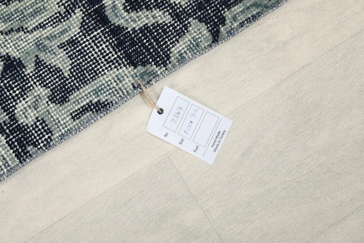 Close-up of the rug's edge with an attached product tag displaying rug information.