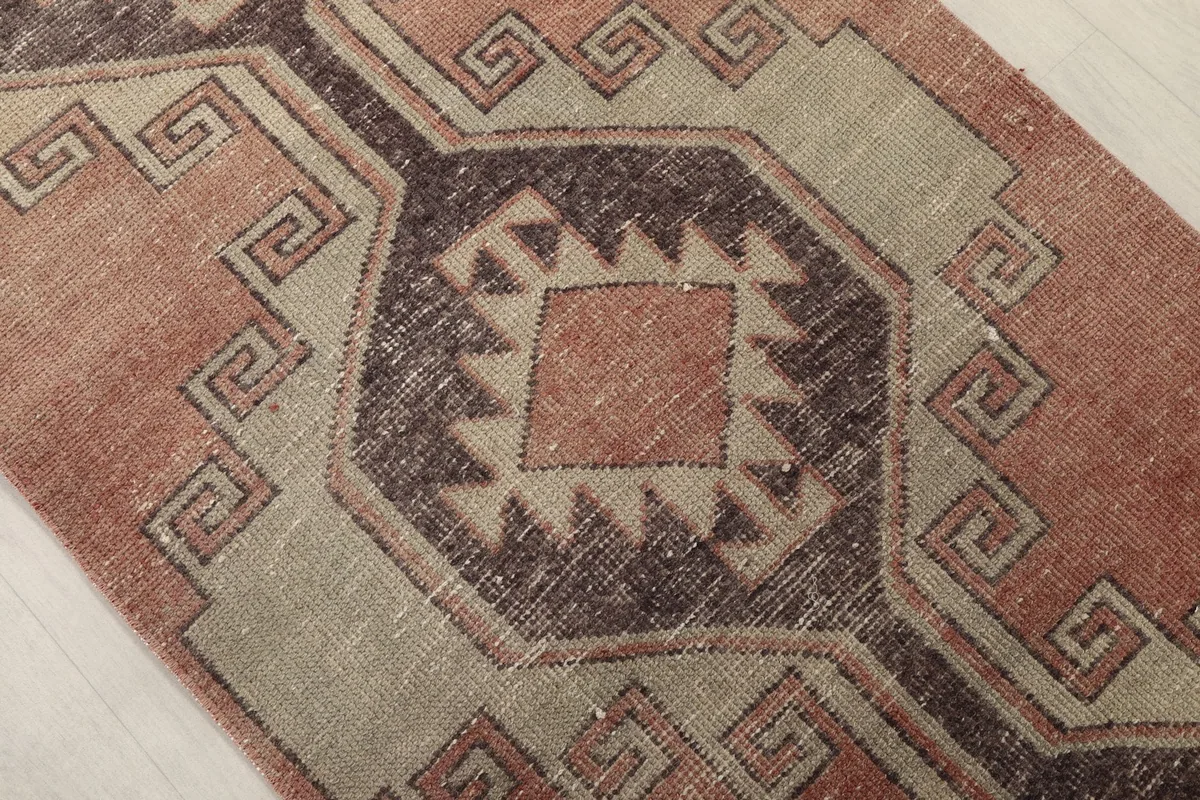 Close-up of a central geometric medallion with rust and charcoal tones