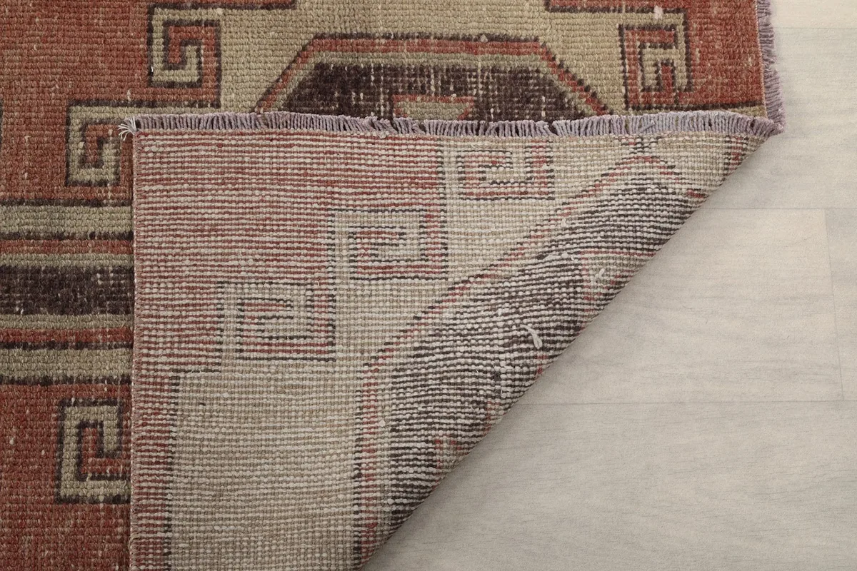 Another view of the rug's reverse side, showing the knotting and fringe