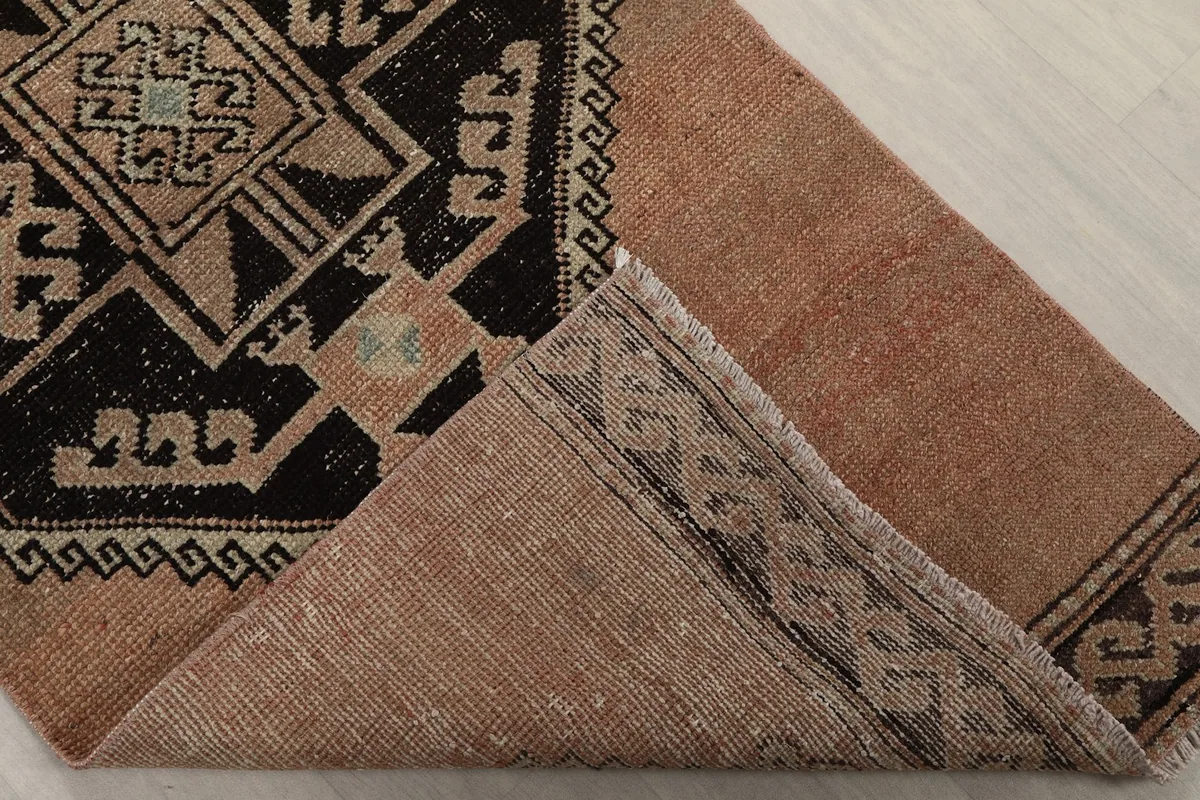 View of the back of the rug, revealing the hand-knotted cotton foundation and the reverse of the pattern
