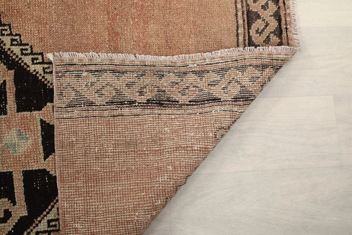 Close-up of the back of the rug, showing the tight weave and the border's reverse side