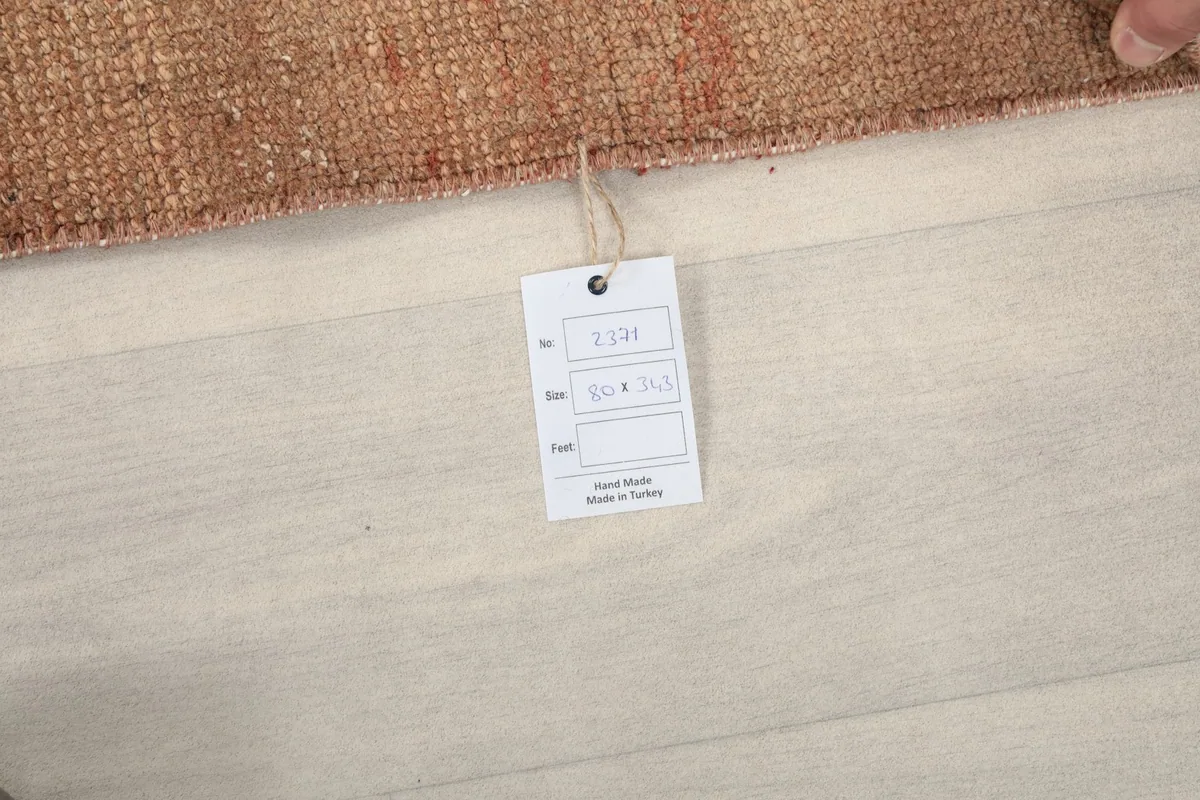 Product tag attached to the rug, indicating its hand-made origin in Turkey and unique item number
