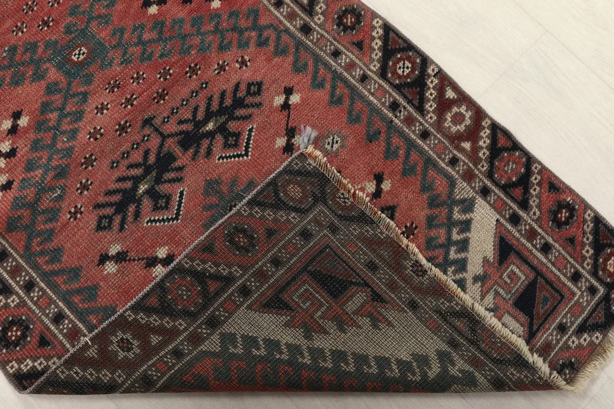 Corner flipped to show the back of the hand-knotted wool pile on cotton foundation.