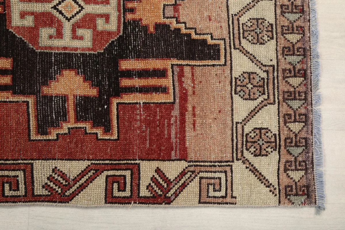 Detailed view of the rug's border and a corner of the main field, highlighting weave and colors