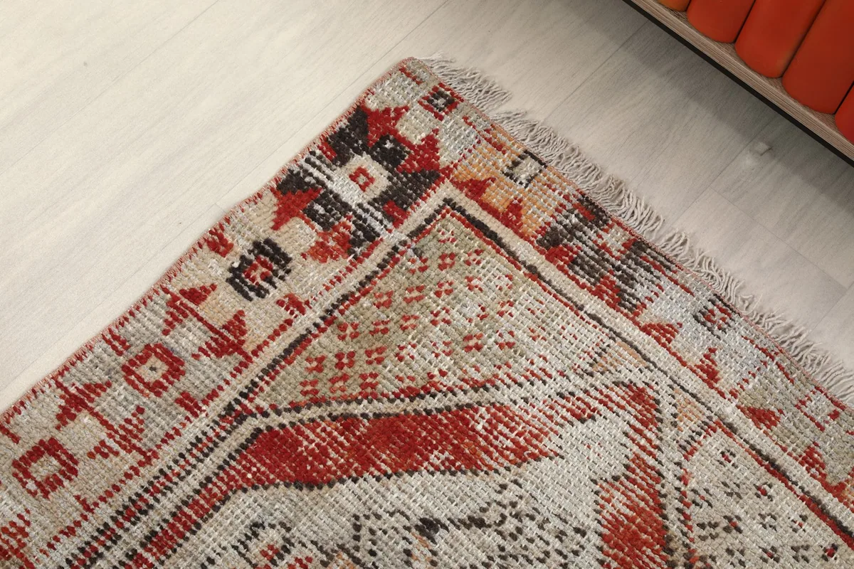 Detail of the rug's corner, showcasing the outer border and inner motifs