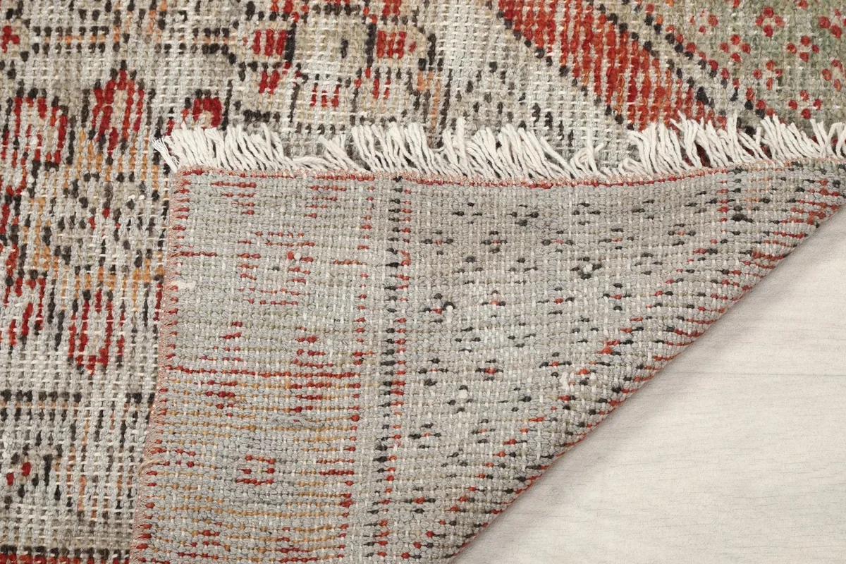 Detail of the rug's back and white fringes, revealing the weaving technique