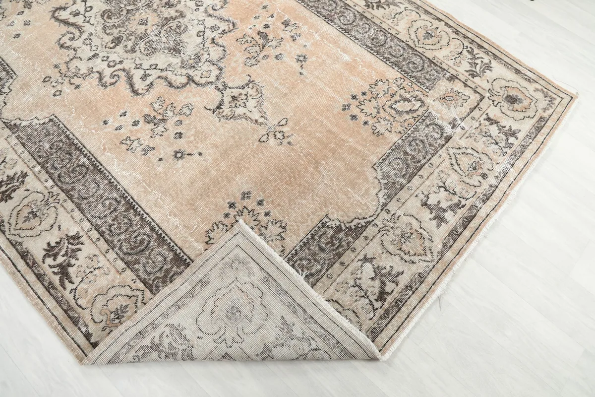 Corner of the rug folded back to show the cotton foundation and reverse side