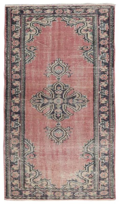 Full overhead view of the vintage rose and navy Anatolian rug on a white background