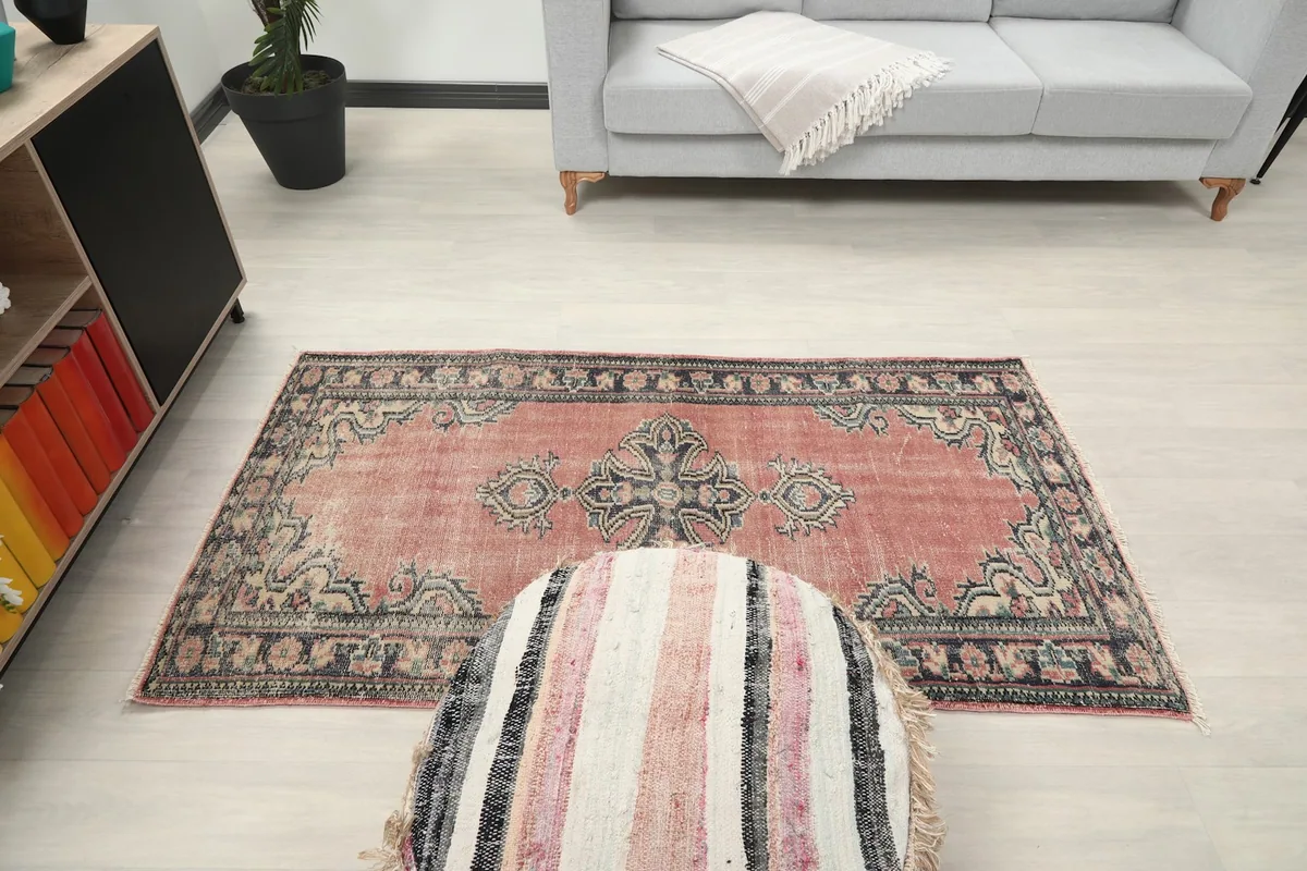 Overhead view of the rug in the room setting, positioned with an ottoman