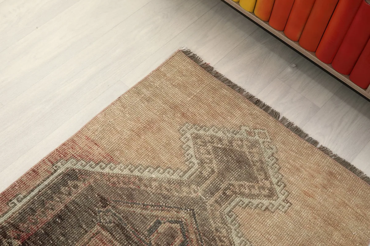 Corner detail of the rug, showing the intricate border design and fringe.