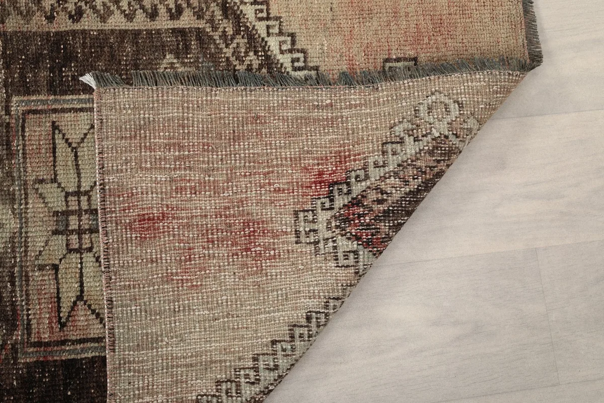 Flipped corner of the rug, showing the reverse side and the hand-knotted structure.