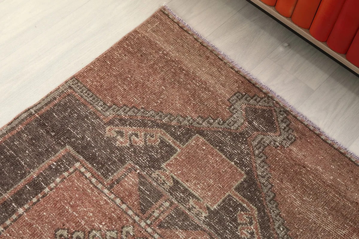 Detail of the rug's edge, showing the transition from the rose field to the charcoal border design.