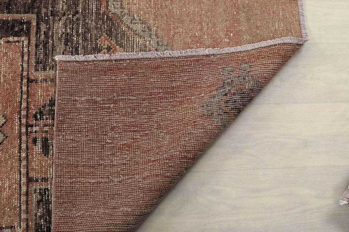 Underside of the rug, showing the tight weave of the wool pile on the cotton foundation.