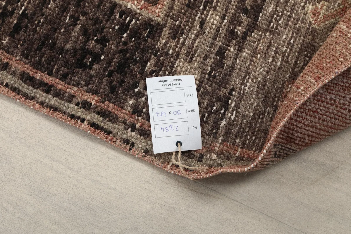 Close-up of the rug's corner with an attached product tag, showing the back of the rug.