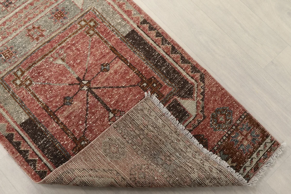 Underside of the hand-knotted wool runner rug, revealing the cotton foundation and knotting.