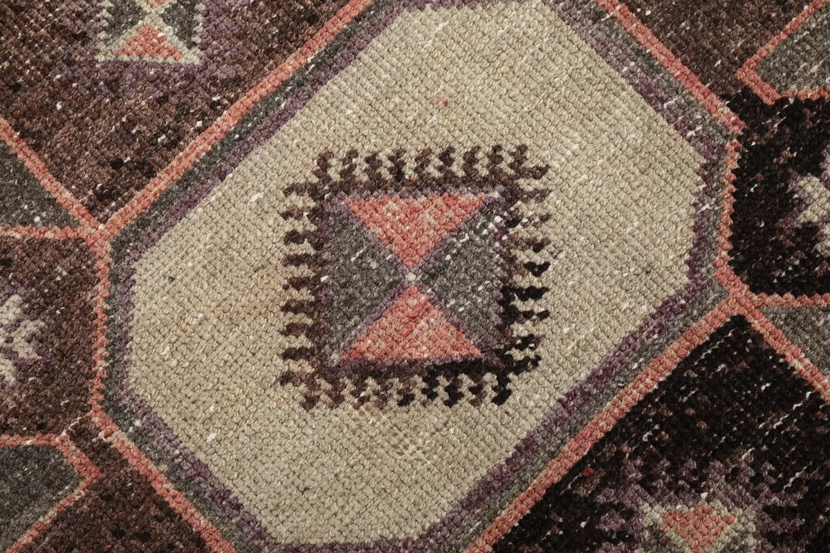 Macro shot of the intricate patterns within a beige geometric motif, showing wool texture