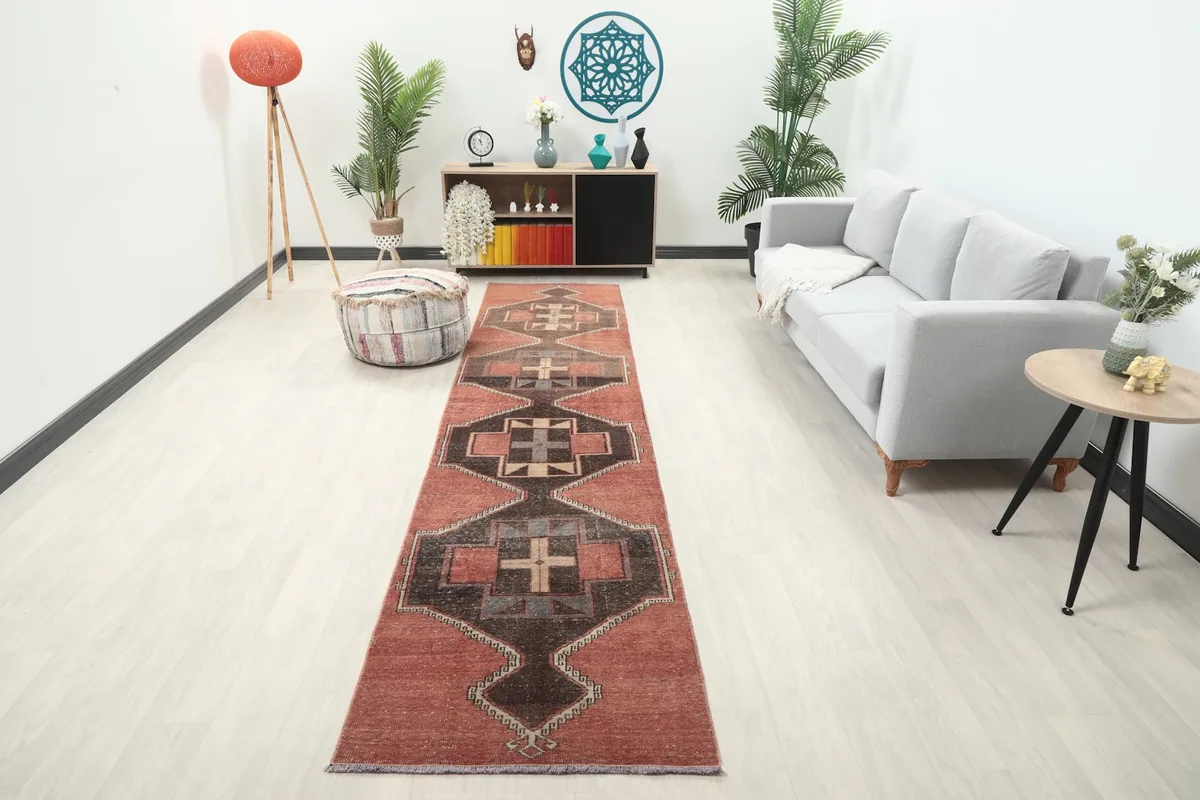 Long runner rug displayed in a bright hallway with a light gray sofa and wooden furniture