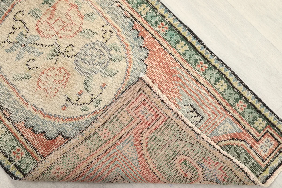 Corner of the rug folded to show the cotton foundation and hand-knotted construction