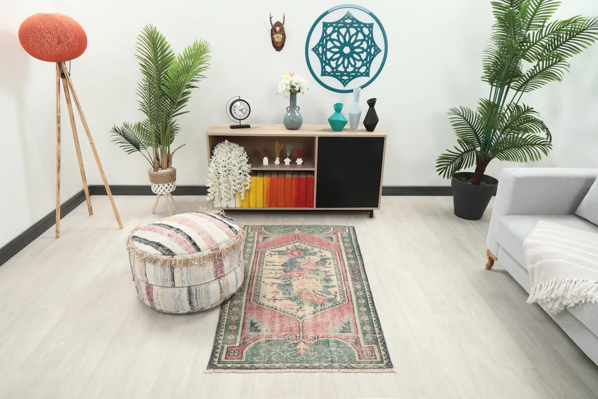 Vintage Anatolian rug in a modern living space with a light gray couch and wooden cabinet.