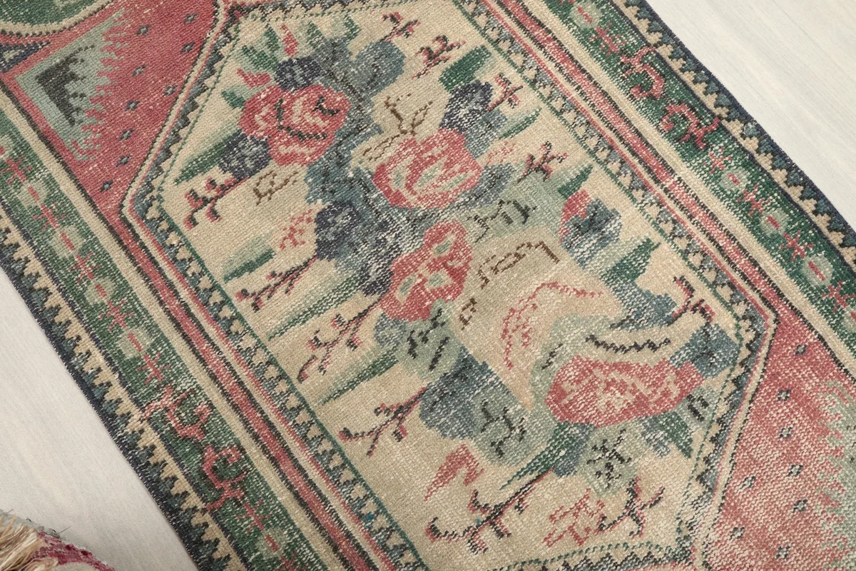 Overhead view focusing on the central floral medallion and surrounding patterns of the rug.