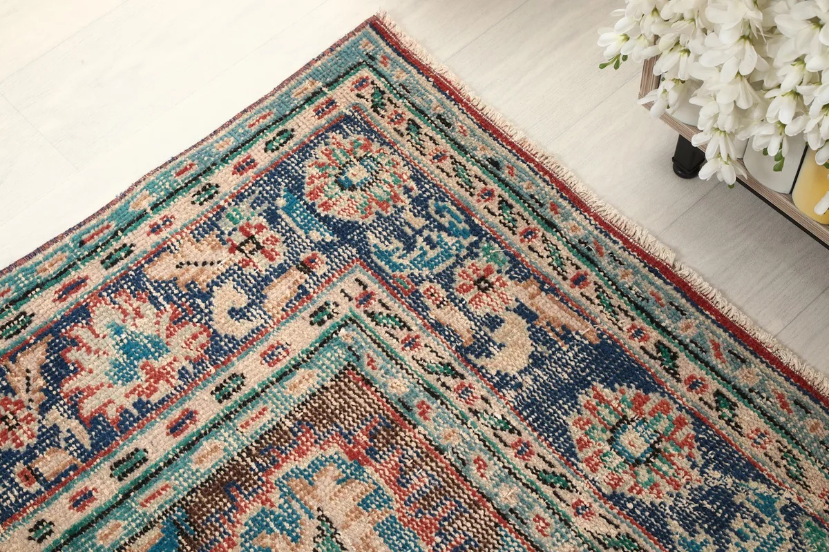 Corner detail of the rug, highlighting the intricate border and color variations.