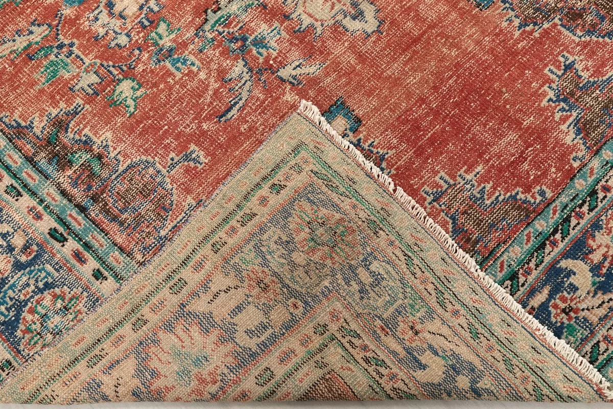 Folded corner revealing the cotton foundation and hand-knotted construction.