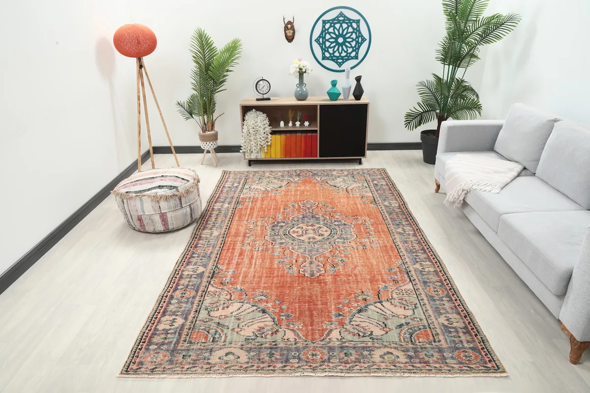 Vintage rust and blue rug in a living room setting, showing its scale and color