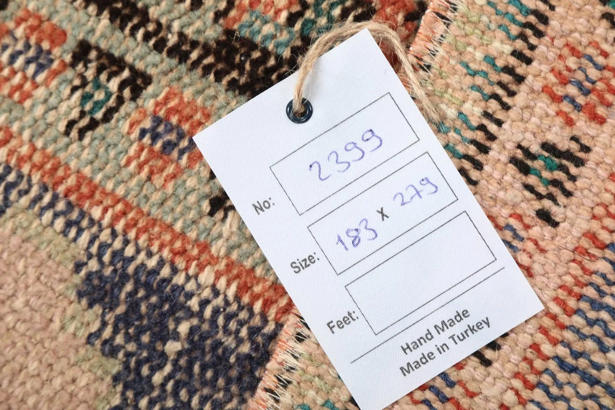 Close-up of the rug's texture with a tag showing its dimensions and origin