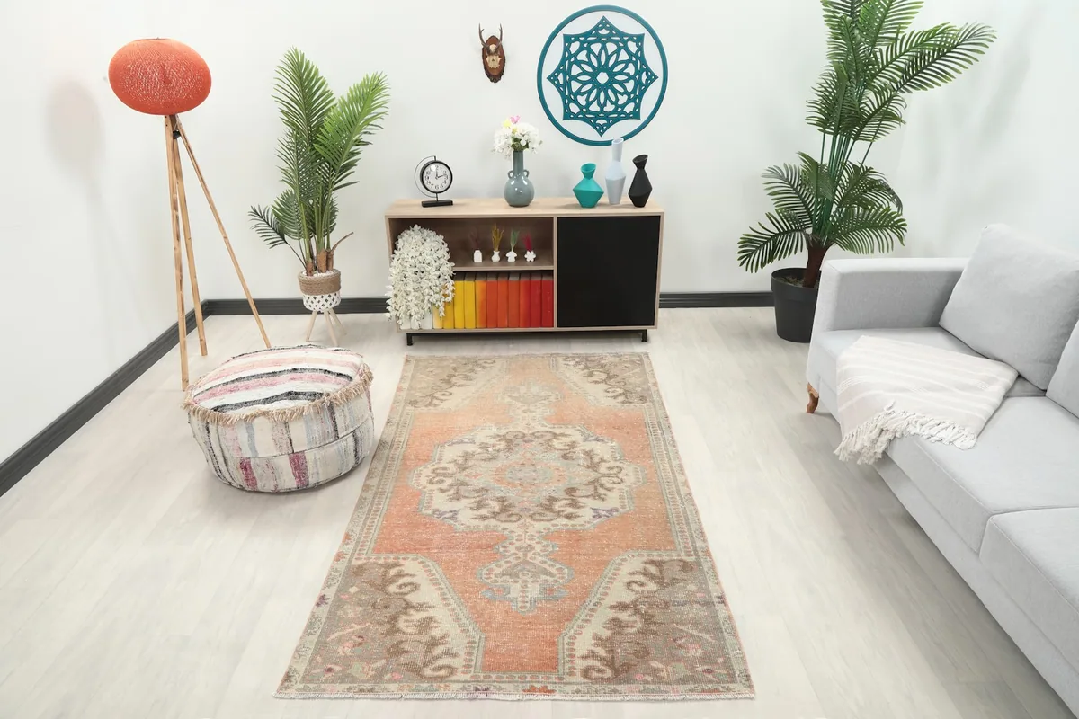 Orange medallion rug displayed in a living room setting with a sofa and console