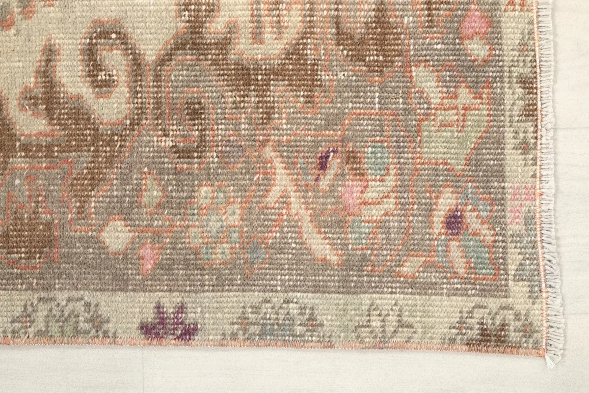 Detail of the rug's corner showing tribal patterns and subtle colors