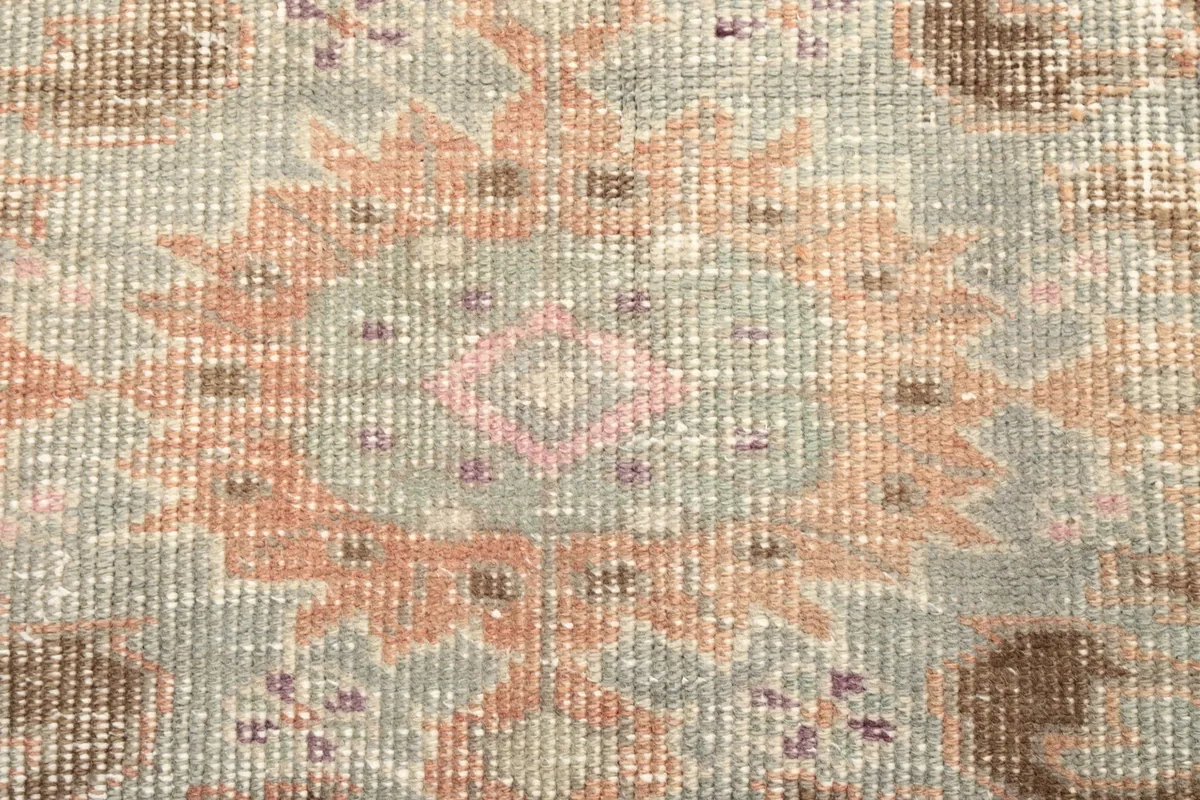 Close-up texture of the hand-knotted wool pile, showing wear and color variations