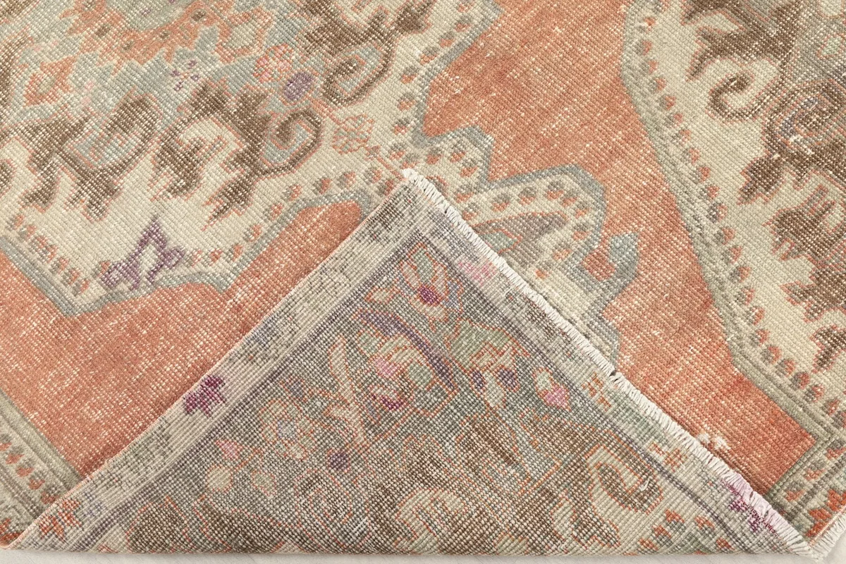 Folded corner of the rug revealing the backside of the hand-knotted cotton foundation