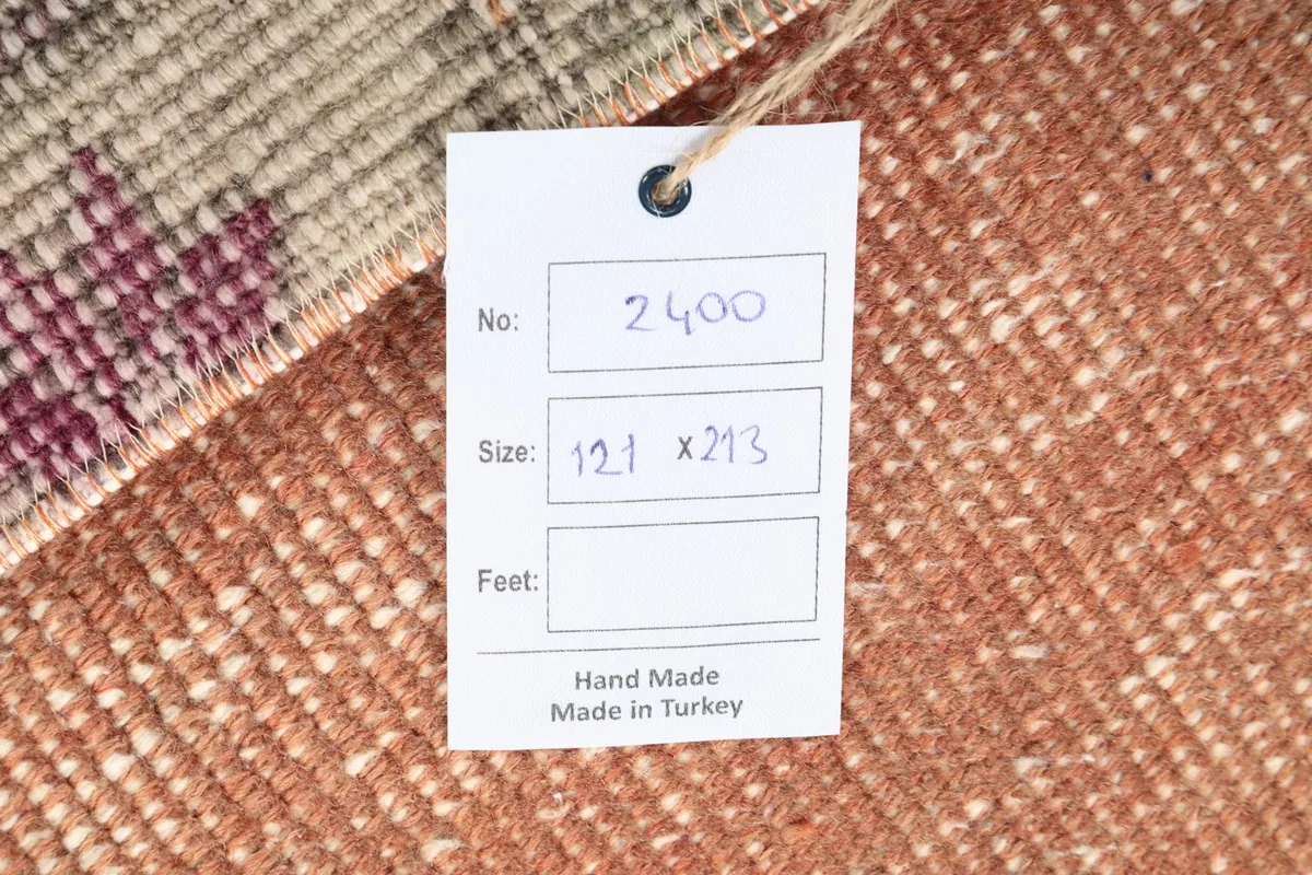 Product tag on the rug showing size in centimeters and 'Hand Made Made in Turkey'