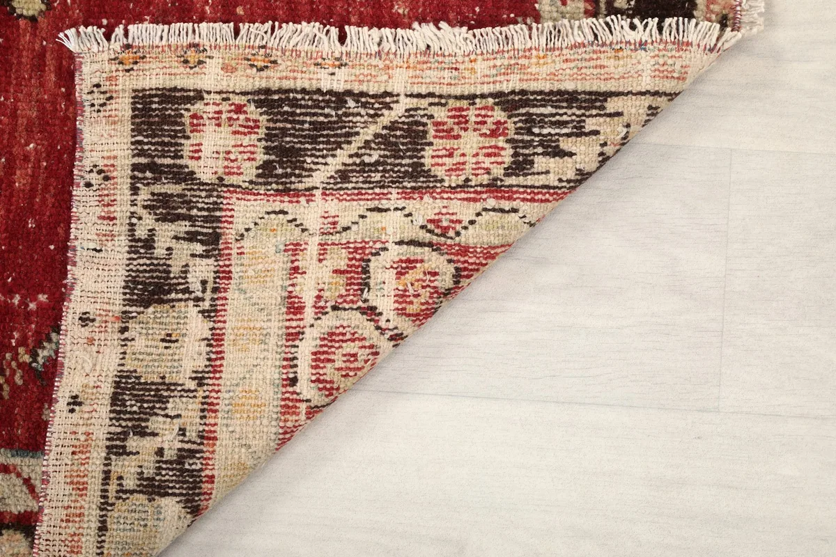 Close-up of the rug's corner, revealing the low wool pile and construction details