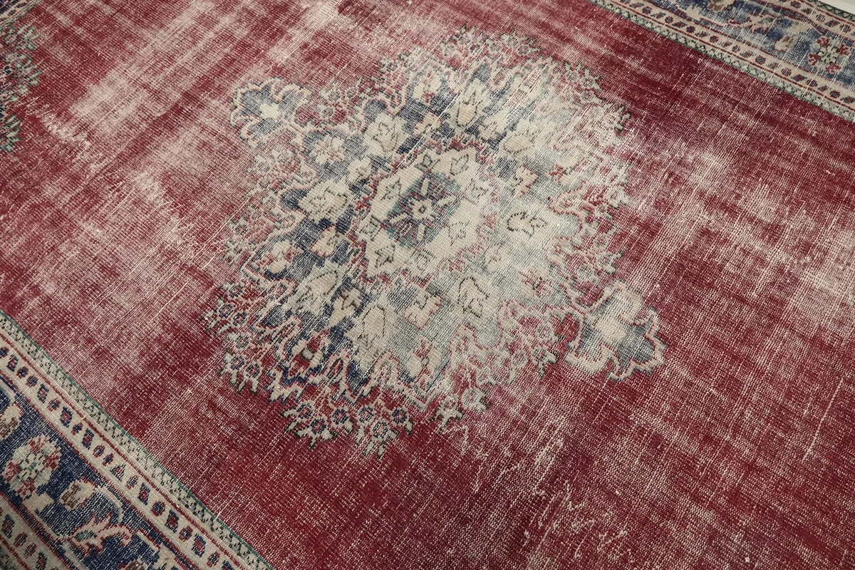Close-up of the faded central medallion with cream, blue, and rust tones