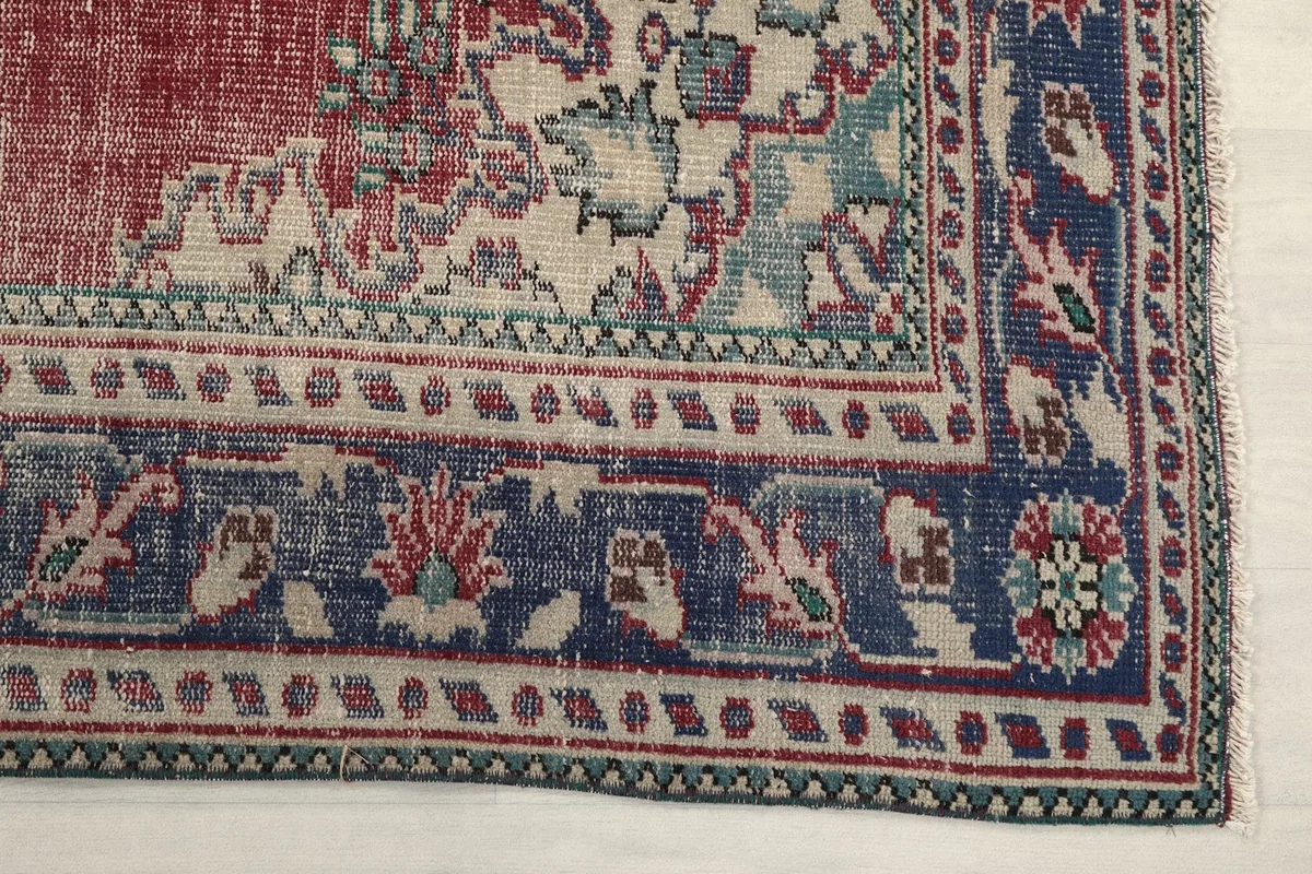 Detail of the navy border with floral and geometric patterns, showing cream and green accents