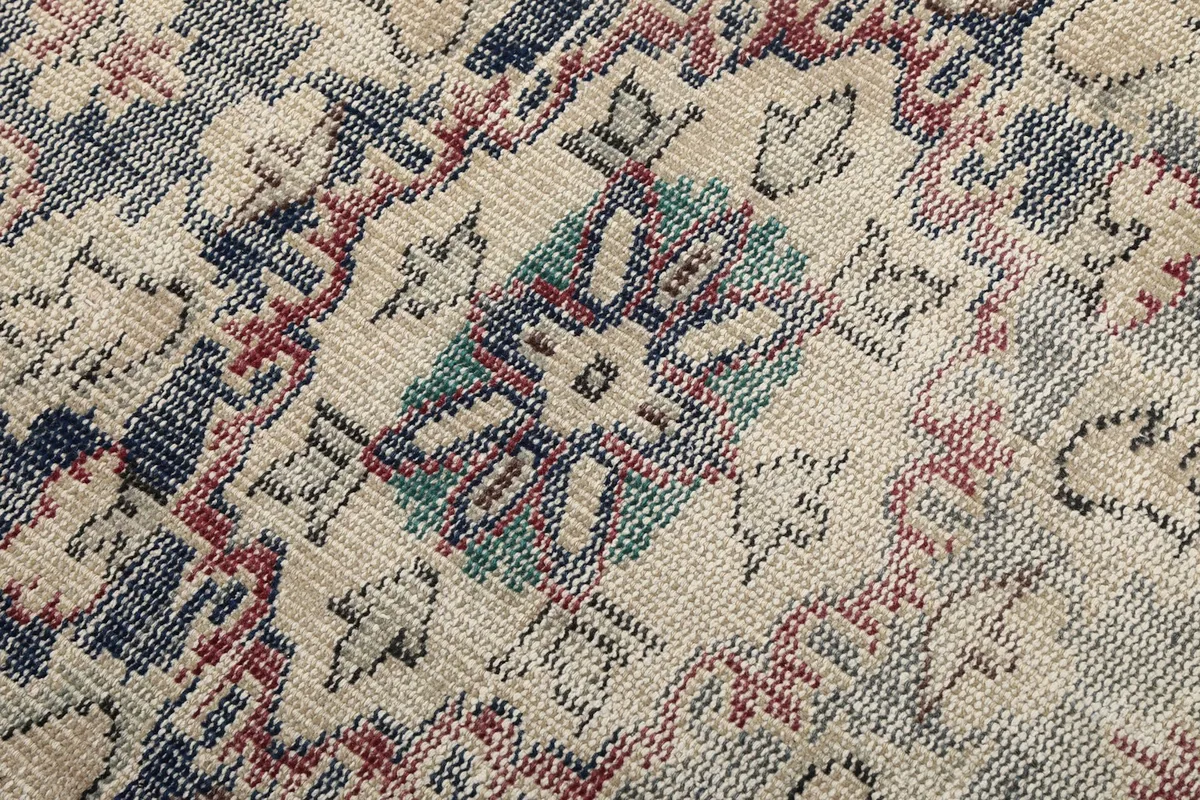 Texture detail of the hand-knotted wool pile, showing individual knots and low pile height