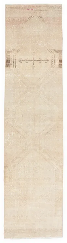 Full overhead view of a beige geometric vintage runner rug on a white background