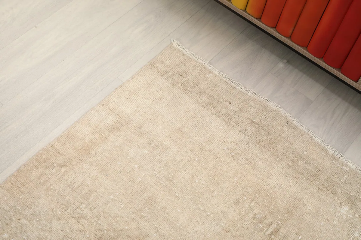 Corner view of the runner rug on a light wooden floor, showing the edge and subtle color variations